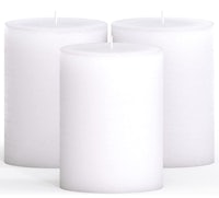 three white pillar candles on a white surface