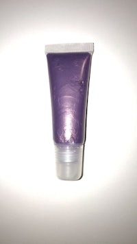 a tube of purple makeup on a white surface