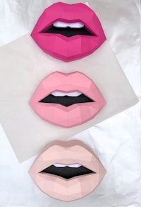 a set of three paper lips in pink, black and white